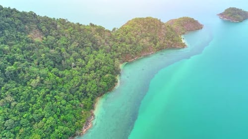 Aerial view reveals lush coastal and mountains on tropical island. 4K.