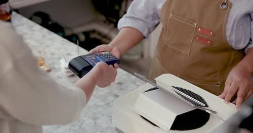 Slowmotion scene of credit card being tapped on payment terminal by caucasian customer during