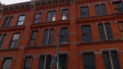 A beautiful smooth driving shot of a red brick building in a downtown area. This old historic landm