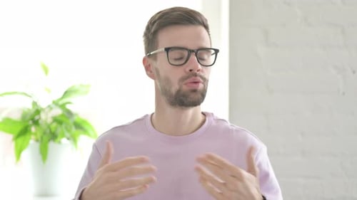 Young Man Talking and Gesturing Indoors