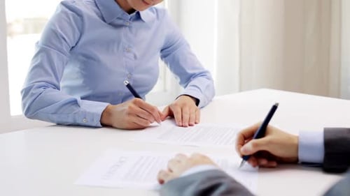 Business partners shake hands after signing contract at modern office
