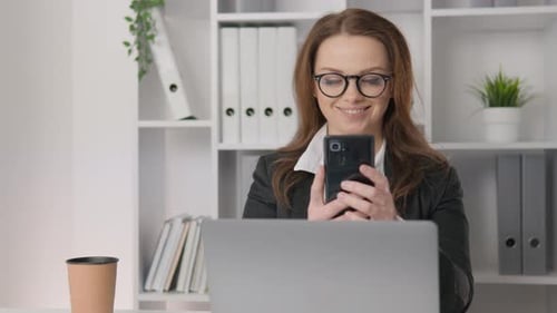 Business Woman Using Phone in Office at Workplace The Businesswoman is Immersed in Work Reviewing