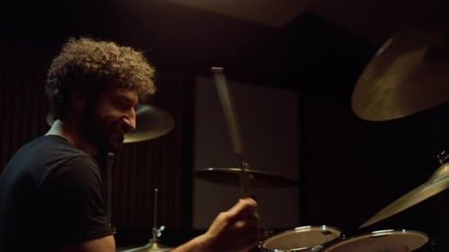 Side View Of Happy Rock Drummer Playing Rock Music In Recording Studio. Joyful Musician Hitting D...