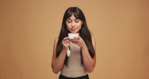 Attractive Woman Enjoys Eating White Yogurt Snack