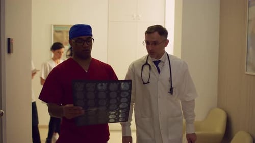 Doctors Reviewing X-Ray in Hospital Hallway