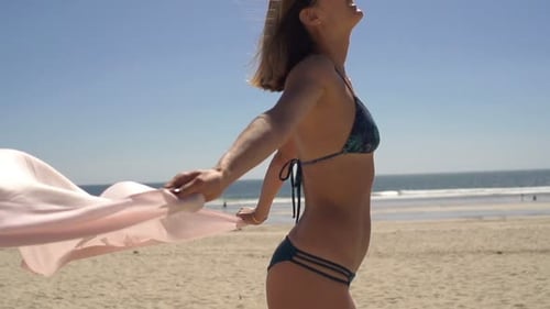 Woman in Bikini with Pareo Enjoying Sunny Day on Beach 30s