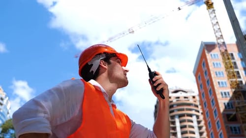 Construction Foreman Using Walkie Talkie at Construction Site
