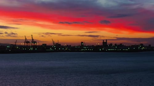 City Skyline Silhouette Across Water at Colorful Sunrise