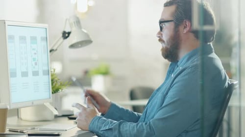 Adult Man Works at Computer in Bright Office