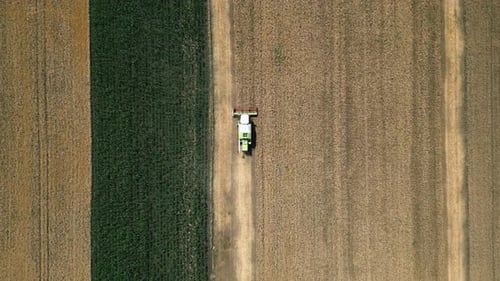 A Breathtaking Aerial View Showcasing an Agricultural Field with a Tractor Working on It