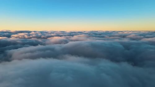Aerial View From Above at High Altitude of Dense Puffy Cumulus Clouds Flying in Evening