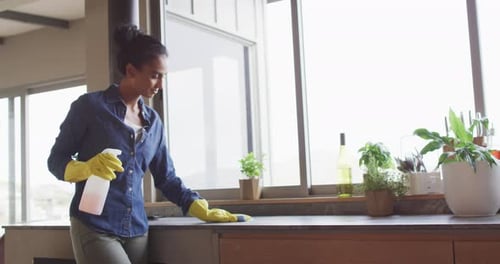 Vídeo de mujer birracial limpiando encimera