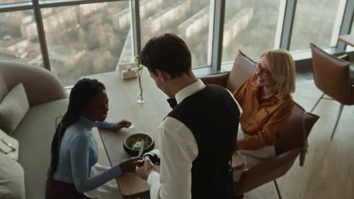 Sommelier Presenting Bottle of Wine to Guests in Modern Restaurant