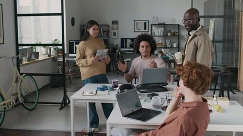 Gruppe multiethnischer junger Entwickler diskutiert Computerprogramm im Büro