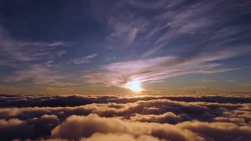 Dramatic Aerial Sunset View Above Dark Sea of Clouds and Blue Sky