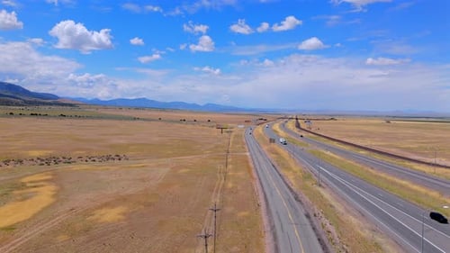 Stunning Aerial Views of a Highway Meandering Through Scenic Plains and Majestic Mountains