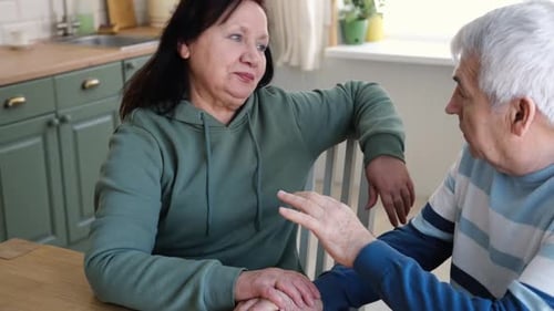 Mature Couple Holding Hands and Talking Indoors