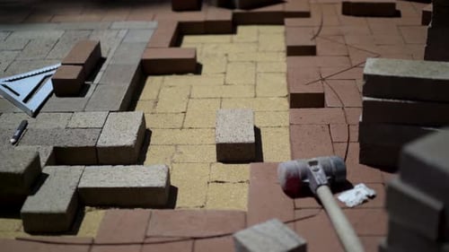 Construction zone detail of brick paver custom emblem in herringbone pattern.