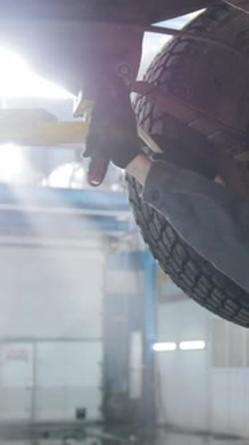 Garage Automobile Service a Mechanic Under Bottom of Car Checks