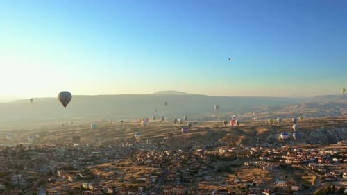 Aerial drone view of colorful hot air balloon flying over Cappadocia at summer sunrise. 4K. 4