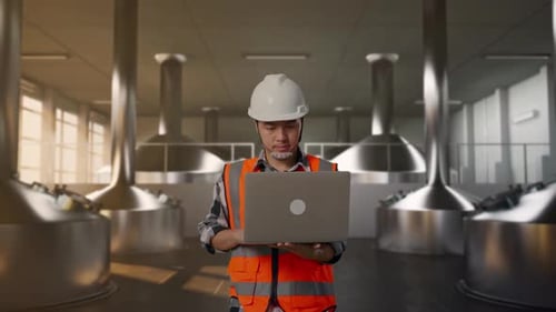 Front View of Asian Male Engineer Use Computer While Walking at Beer Plant