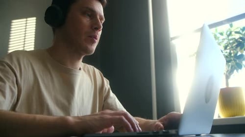 Man With Headphones Using Laptop for Video Call