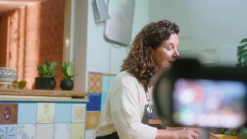 Food-Bloggerin filmt Kochstunde mit Kamera auf Stativ
