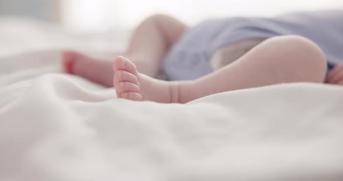 Baby Lying on Bed with Small Feet