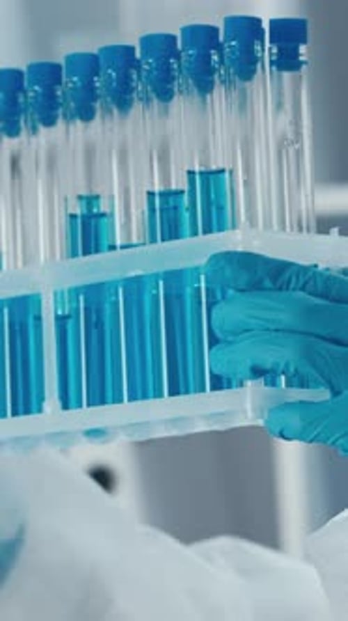 Scientist Holds Test Tubes with Blue Liquid in Lab