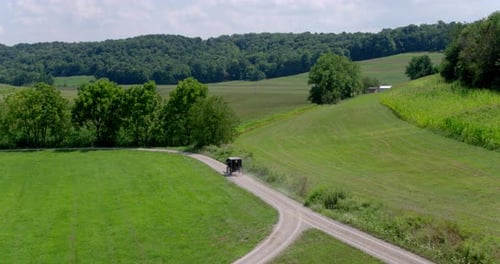 Amish buggy travels a rural road in lancaster county Pennsylvania drone view