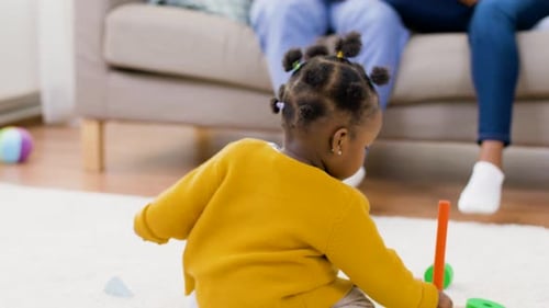 Baby Playing with Toys on Rug Indoors