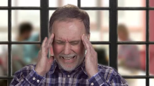 Senior Adult Rubbing Temples Experiencing a Headache
