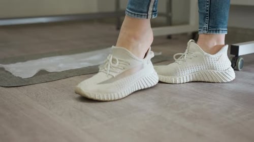 Feet with Red Toenails Taking Off White Shoes