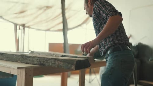 Carpenter Measuring a Wooden Plank in His Workshop
