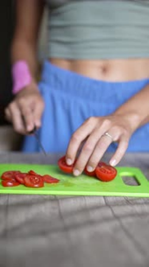 Woman Slicing Tomato on Cutting Board at Home