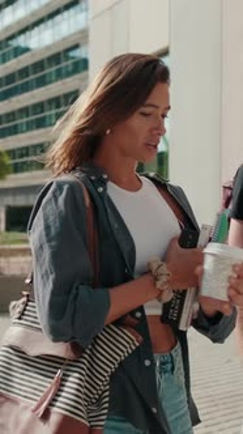 two female and male students walking around the city, going down the stairs and talking