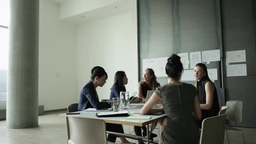 Businesswomen Collaborating Around Table in Modern Office