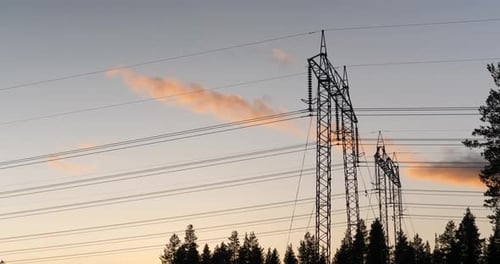 Electrical Transmission Towers in Rural Landscape at Sunset