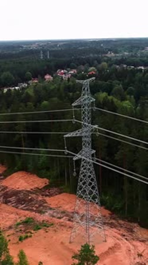 Aerial pullback, electricity tower pylon with wire cables crossing through tall forest, energy suppl