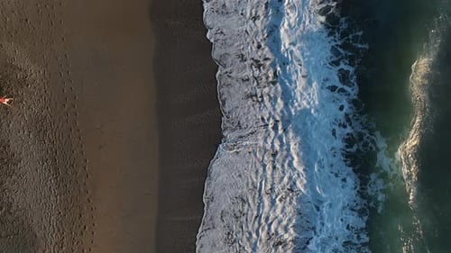 Dramatisch Farbe der Meereswellen, die gegen die Felsen prallen, Luftbild an einem wilden Strand