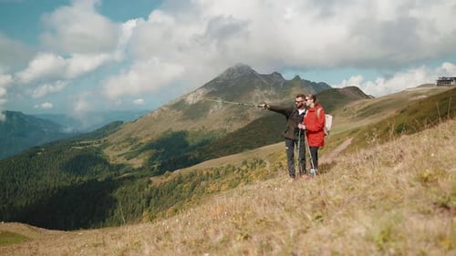 Hikers Tourists Man and Woman Discuss Route Stand on Mountain Slope in Hike