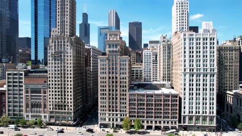 Chicago cityscape showing high rise dense concrete buildings and skyscrapers on sunny day. Sliding a