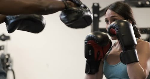 Woman Boxing with Trainer at the Gym