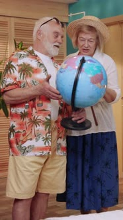 Senior Couple Planning Travel with Globe at Home