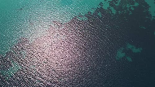 Closeup Aerial View of Crystalclear Turquoise Sea Water with Visible Textures and Gentle Ripples