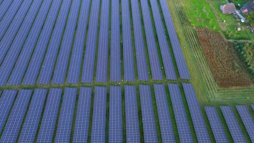 Pan up aerial small solar farm on Dutch farmland promoting sustainable energy