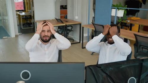 Zwei gestresste Händler schauen auf den Bildschirm und zeigen, dass die Grafik des Finanzmarkt-Charts nach unten geht