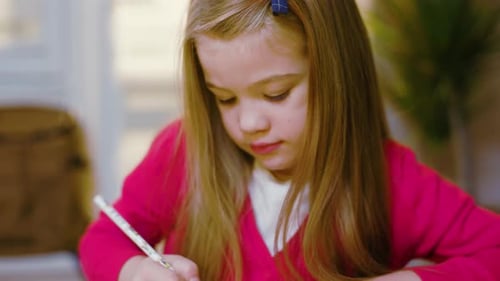 Little Girl Concentrating on Drawing at Home