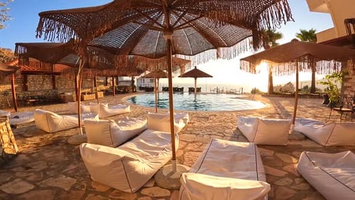 Pool by the beach at sunset with reflection of palm trees, tropical landscape, exotic island hotel o