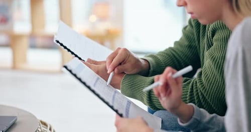 Adults Review Documents with Pens in Bright Room